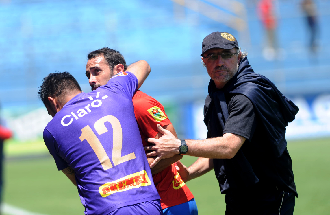 Gastón Puerari observa a un aficionado rojo que lo insultó durante el juego contra Malacateco. Lo calman Paulo Motta y el técnico Gustavo Machaín. (Foto Prensa Libre: Edwin Fajardo)