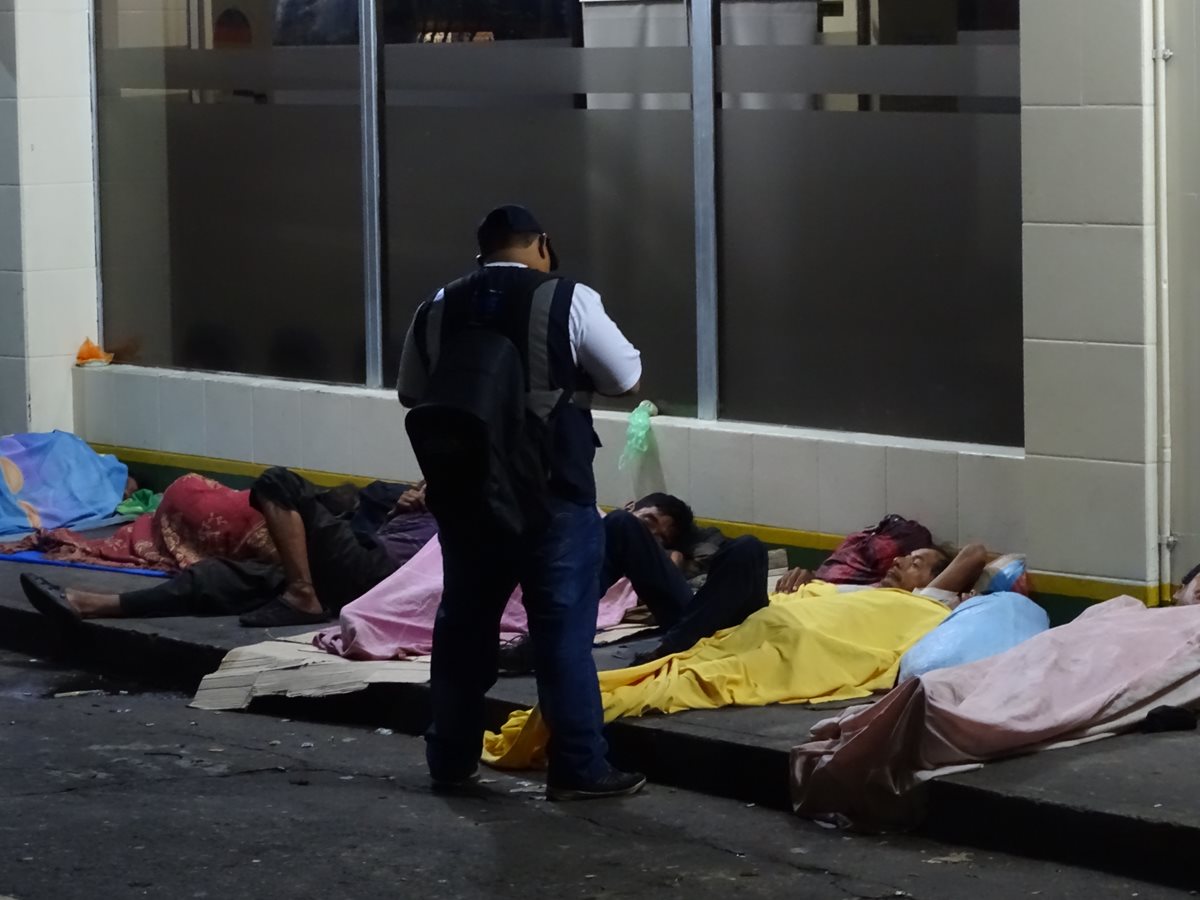 Censista solicita información a personas que duermen en una banqueta en Mazatenango. (Foto Prensa Libre: Cristian Soto).