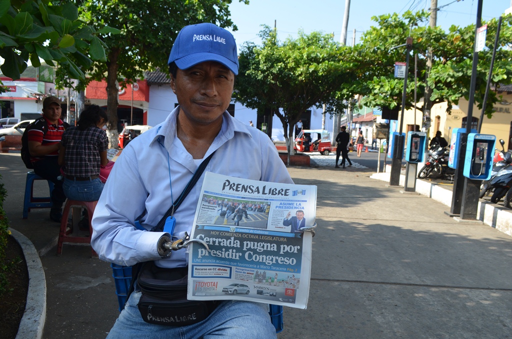 Enrique Rodríguez ofrece periódico en el parque central de la cabecera de Retalhuleu. (Foto Prensa Libre: Jorge Tizol).