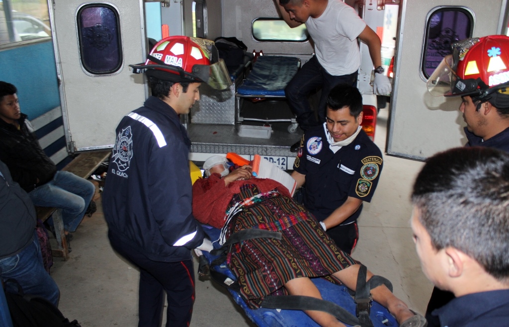 Bomberos Municipales ingresan en el Hospital Regional de Quiché a una de las personas heridas en una fuerte colisión en Chichicastenango. (Foto Prensa Libre: Óscar Figueroa).