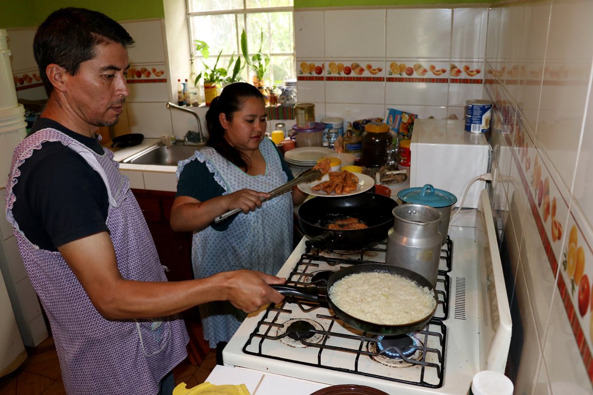 Lorenzo Castillo y Alma Gómez preparan carne de conejo para servir en el almuerzo. (Foto Prensa Libre: Mike Castillo)