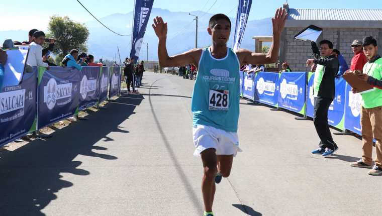 Carlos González levanta los brazos en señal de victoria al finalizar la carrera de 11 kilómetros. (Foto Prensa Libre: AFP)