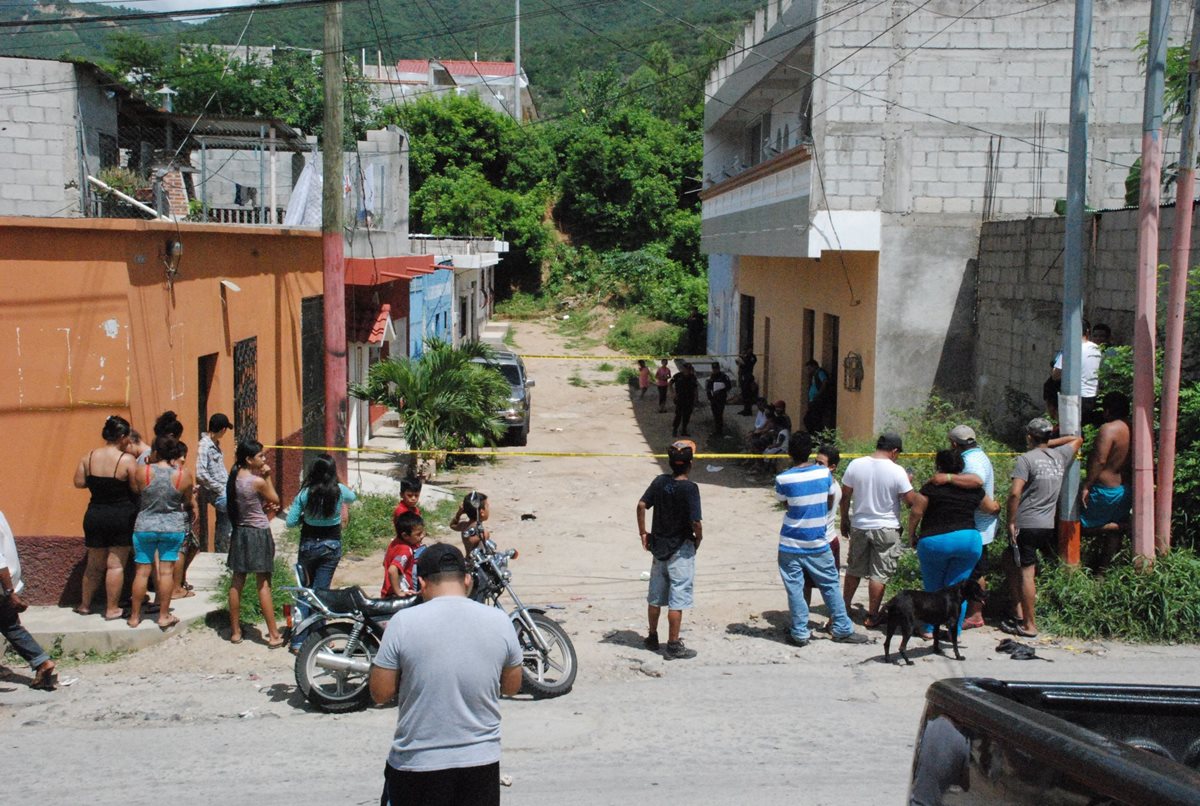 Vecinos de la colonia Linda Vista, zona 2 de Chiquimula, observan el lugar donde quedó el carro en el que murió baleada Belsy Rosmery Pérez Mejía. (Foto Prensa Libre: Mario Morales)