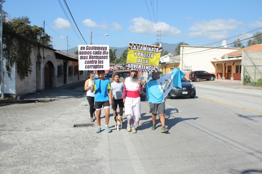 Un grupo de personas acompaña a Osbaldo Ochoa a su paso por Antigua Guatemala, Sacatepéquez. (Foto Prensa Libre: Miguel López).