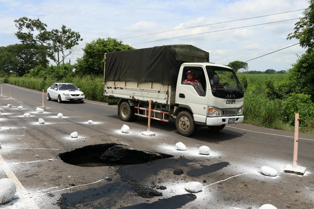El agujero que se produjo la mañana del martes en el kilómetro 82 de la ruta de Escuintla a Taxisco, Santa Rosa, pone en peligro su integridad al transitan por el lugar. (Foto Prensa Libre: Carlos Paredes)