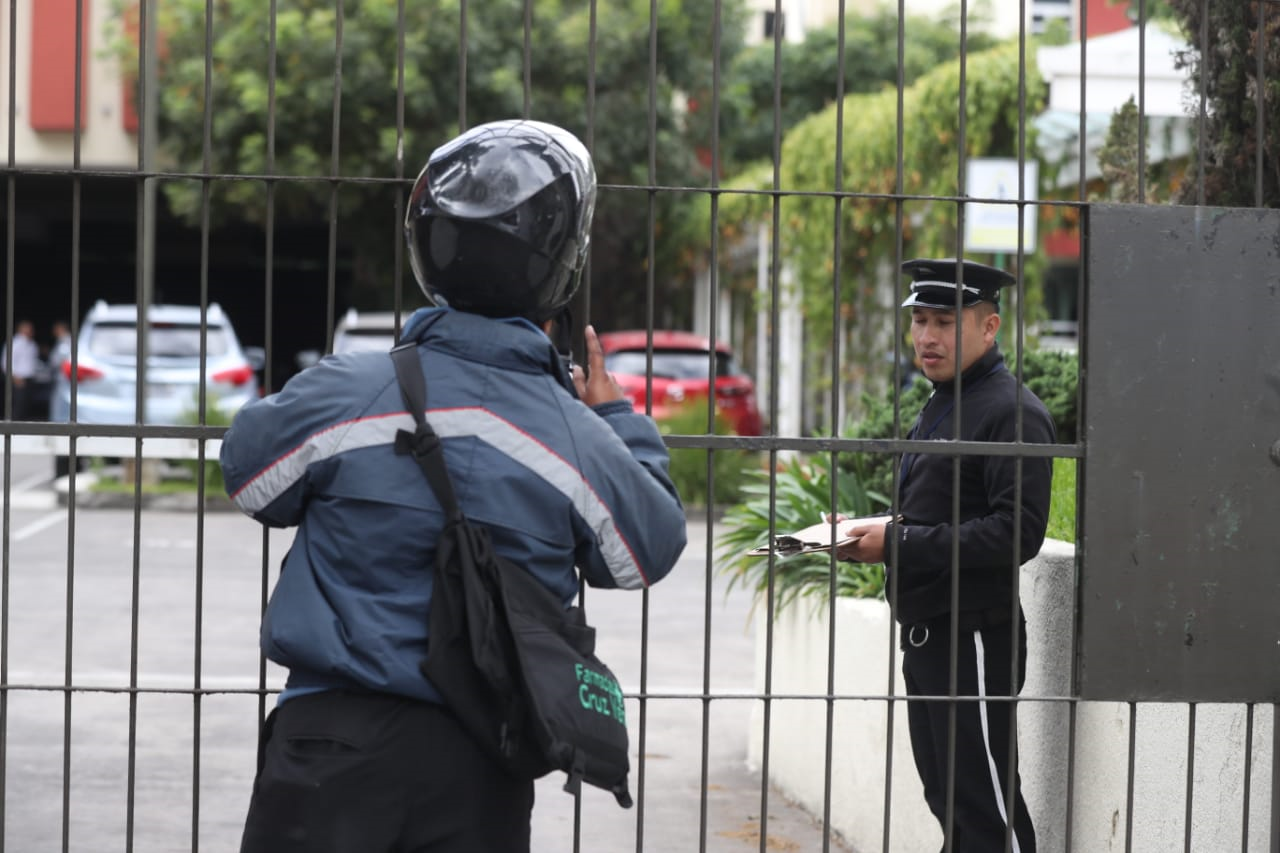 Un mensajero consulta a un guardia de seguridad si alguien podría recibirle unos documentos, pero la respuesta fue negativa. (Foto Prensa Libre: Óscar Rivas)