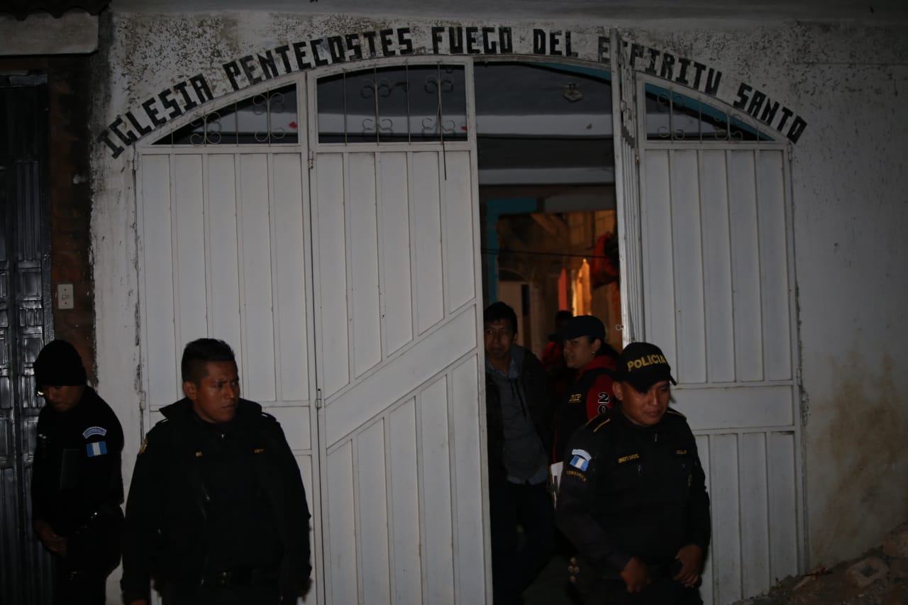 Agentes custodian el inmueble donde fue encontrado el cadáver. (Foto Prensa Libre: PNC)