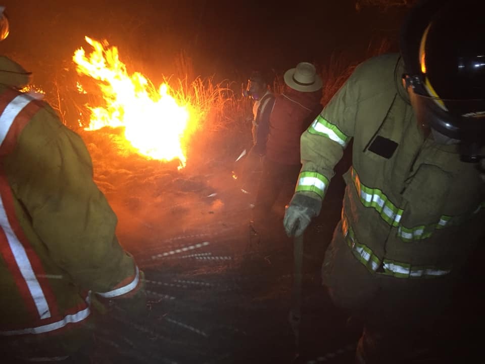 Vecinos y bomberos intenta apagar un incendio forestal en Rancho de Teja, Sacapulas, Quiché, donde murió una mujer que protegía su vivienda. (Foto Prensa Libre: Héctor Cordero)
