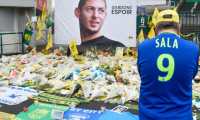 A supporter stands in front of flowers placed in front of a giant portrait of Argentinian former Nantes' forward Emilianio Sala outside La Beaujoire stadium before the French Cup football match between FC Nantes and Toulouse FC in Nantes on February 5, 2019. (Photo by Sebastien SALOM-GOMIS / AFP)