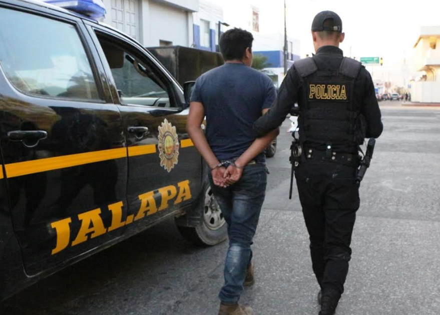 Agente de la PNC custodia a Henry Geovany López Méndez, quien fue capturado en Jalapa por portar licencia de conducir falsa.(Foto Prensa Libre: José Boya).
