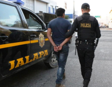 Agente de la PNC custodia a Henry Geovany López Méndez, quien fue capturado en Jalapa por portar licencia de conducir falsa.(Foto Prensa Libre: José Boya).