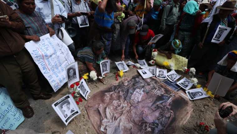 Víctimas del conflicto armado interno colocan fotografías frente al Congreso de sus familiares desaparecidos o  muertos durante el conflicto armado interno. (Foto Prensa Libre: Esbin García) 