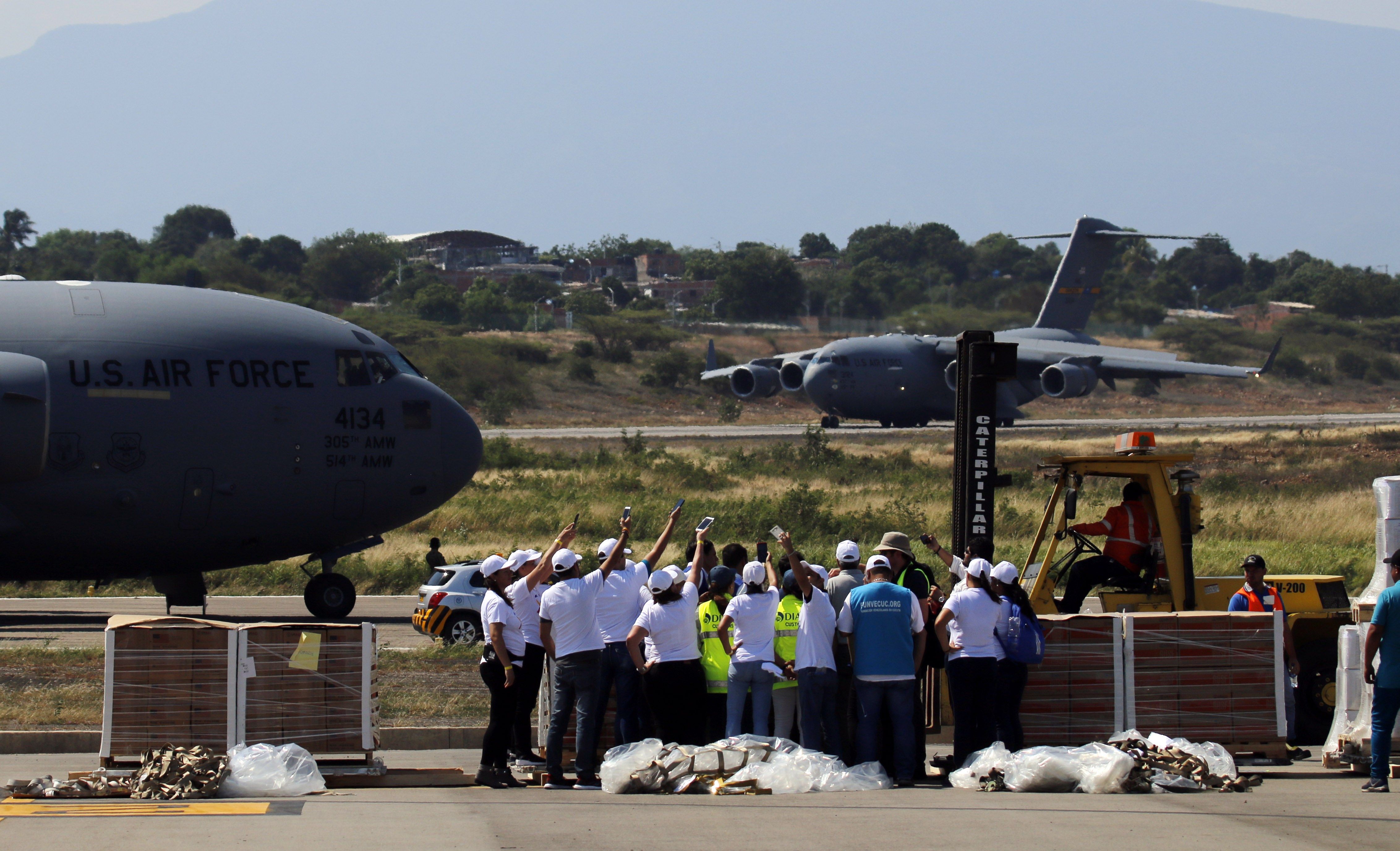 Trabajadores descargan las ayudas del primero de tres aviones de carga C-17 de la Fuerza Aérea de Estados Unidos y celebran el aterrizaje del segundo avión este sábado en el aeropuerto Camilo Daza de Cúcuta (Colombia), con ayuda humanitaria para Venezuela. (Foto, Prensa Libre: Efe). 