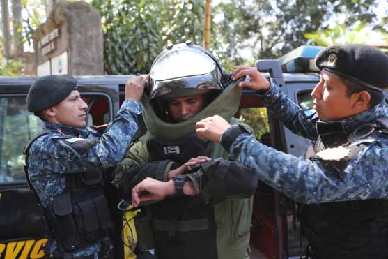 El agente designado para desactivar explosivos, es auxiliado por sus demás compañeros para colocarse el traje protector. Foto Prensa Libre: Erick Avila.