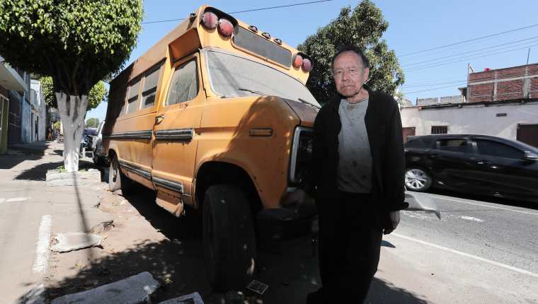 Juan Pablo Figueroa Alfaro junto al bus escolar en el que vive ene la zona 12. (Foto Prensa Libre: Juan Diego González).