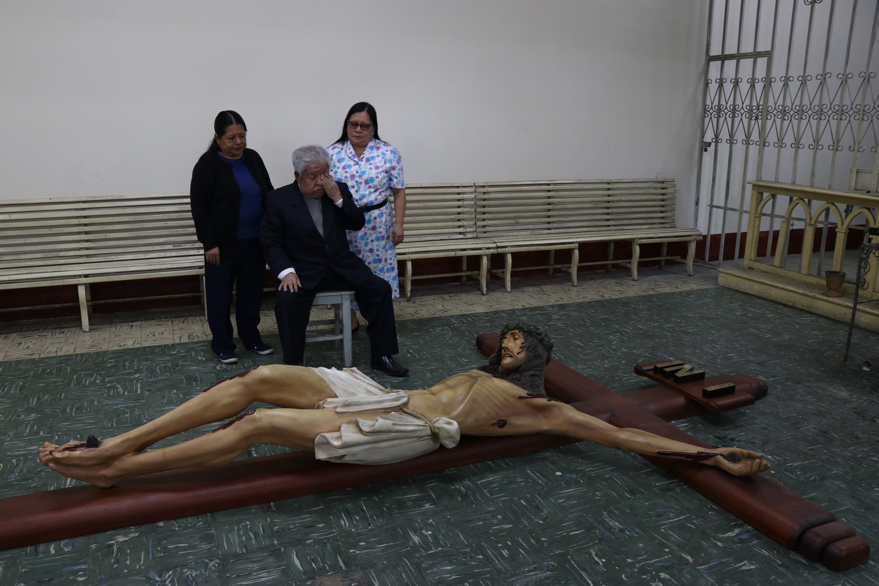 Florentín López Xicará junto a dos de sus hijas observa la imagen que donó y que le recuerda a su esposa. (Foto Prensa Libre: María José Longo)