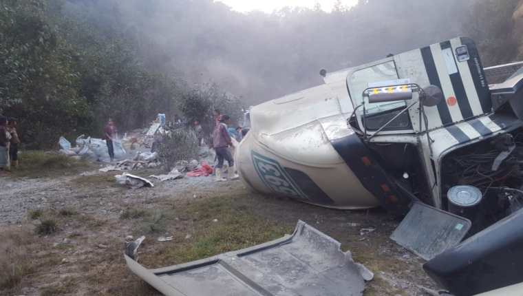 Mientras el tráiler estaba volcado en la cinta asfáltica las personas hurtaban el cemento que se cayó del vehículo, (Foto Prensa Libre: Héctor Cordero).