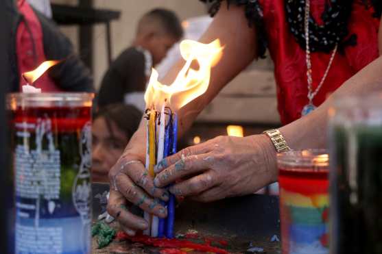Mujer sostiene velas y soporte dolor de la cera caliente. (Foto Prensa Libre: Mike Castillo)