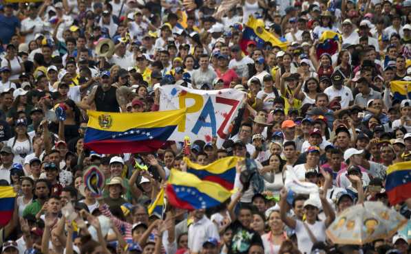 La gente espera el inicio del concierto "Venezuela Aid Live" con un mensaje de paz. AFP