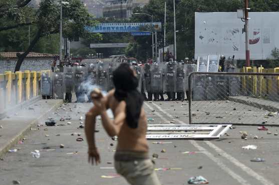 Los manifestantes se enfrentan a la policía nacional venezolana en el puente Simón Bolívar, en Cúcuta, Colombia, luego de que el gobierno del presidente Nicolás Maduro ordenó el cierre temporal de la frontera con Colombia. AFP