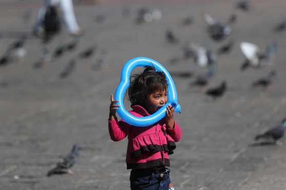 Una niña juega con un globo en forma de corazón en la Plaza de la Constitución. (Foto Prensa Libre: Érick Ávila)