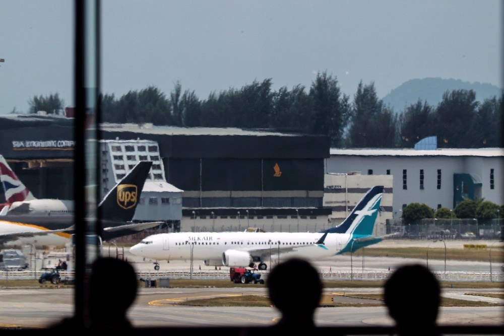 EPA2299. SINGAPUR (SINGAPUR), 12/03/2019.- Varios viajeros observan el avión Boeing 737 Max 8 de la aerolínea Silkair cerca de los hangares este martes en el aeropuerto Changi de Singapur. Las autoridades de Singapur anunciaron la suspensión temporal de todos los vuelos del avión Boeing 737 MAX, a raíz del accidente el domingo de una aeronave de este modelo en Etiopía. EFE/ Wallace Woon