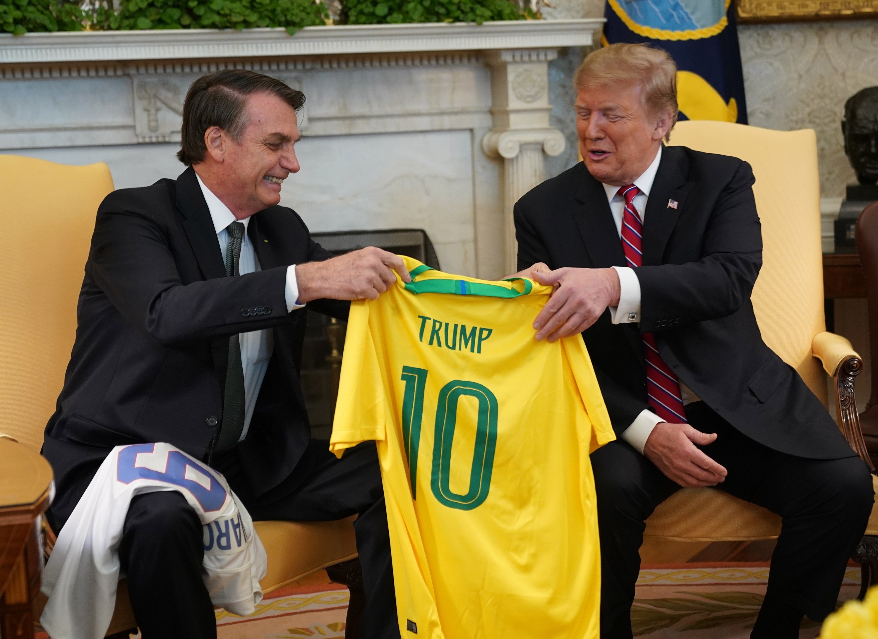El presidente de Estados Unidos, Donald Trump, recibe una camiseta oficial de la selección de fútbol de Brasil durante la reunión mantenida con su homólogo brasileño, Jair Bolsonaro, en la Casa Blanca.  (Foto Prensa Libre: EFE)