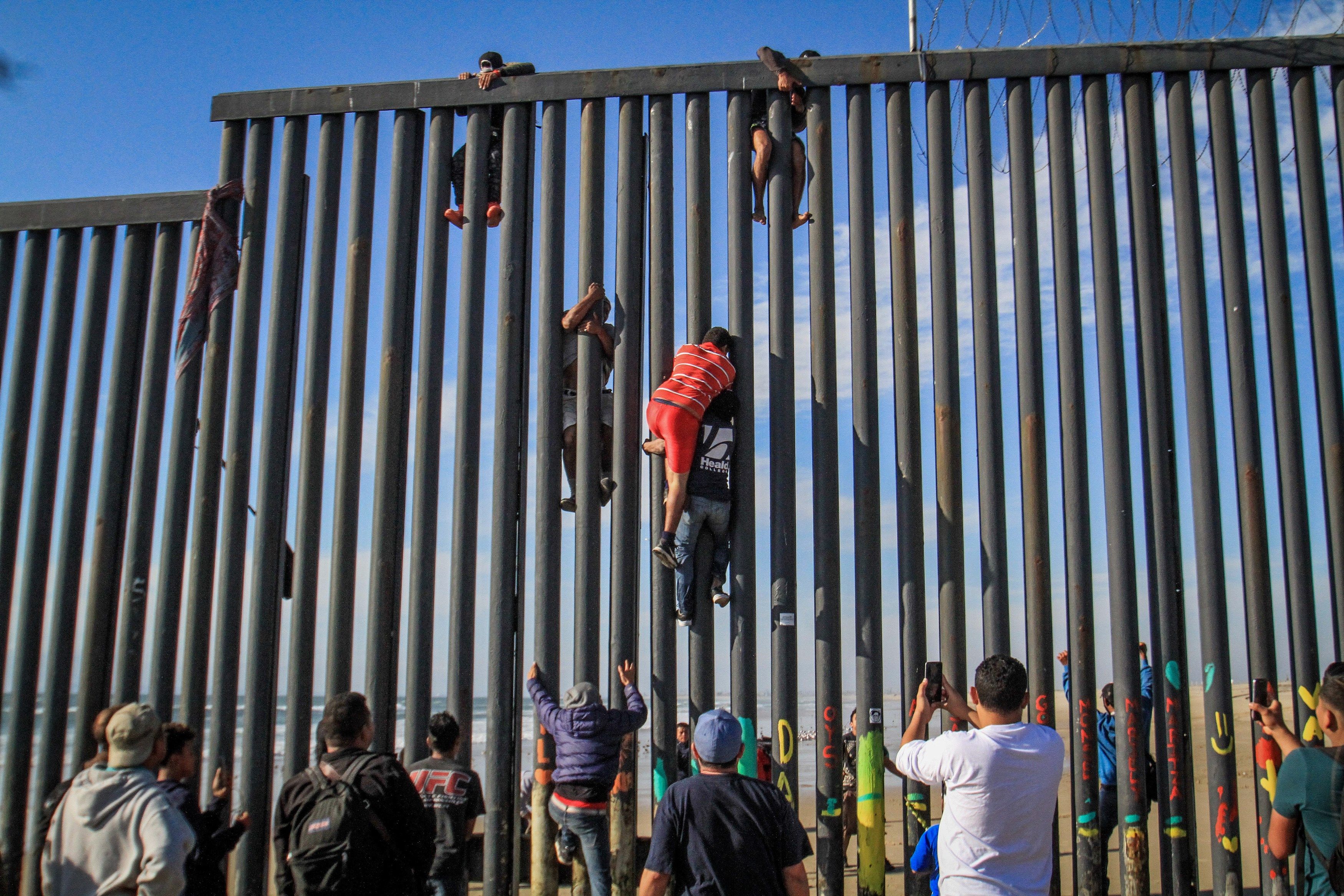 Decenas de migrantes intentan saltar el muro en las playas Tijuana. (Foto Prensa Libre: EFE)