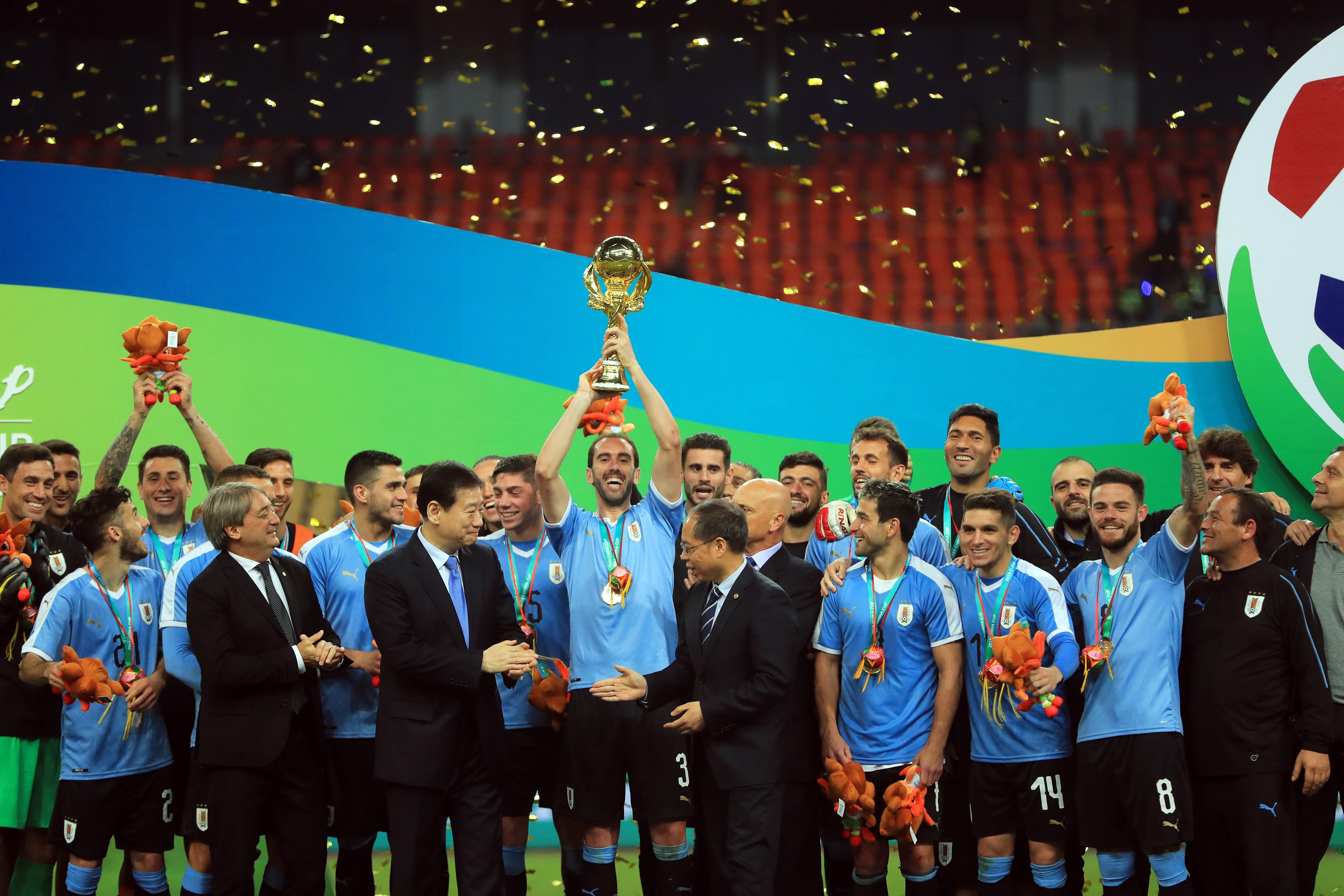 El defensa y capitán de la selección uruguaya, Diego Godín, levanta el trofeo tras la final de la China Cup. (Foto Prensa Libre: EFE)