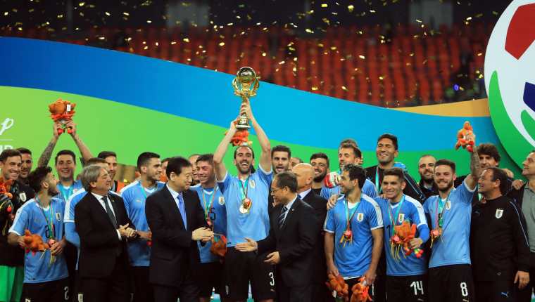 El defensa y capitán de la selección uruguaya, Diego Godín, levanta el trofeo tras la final de la China Cup. (Foto Prensa Libre: EFE)
