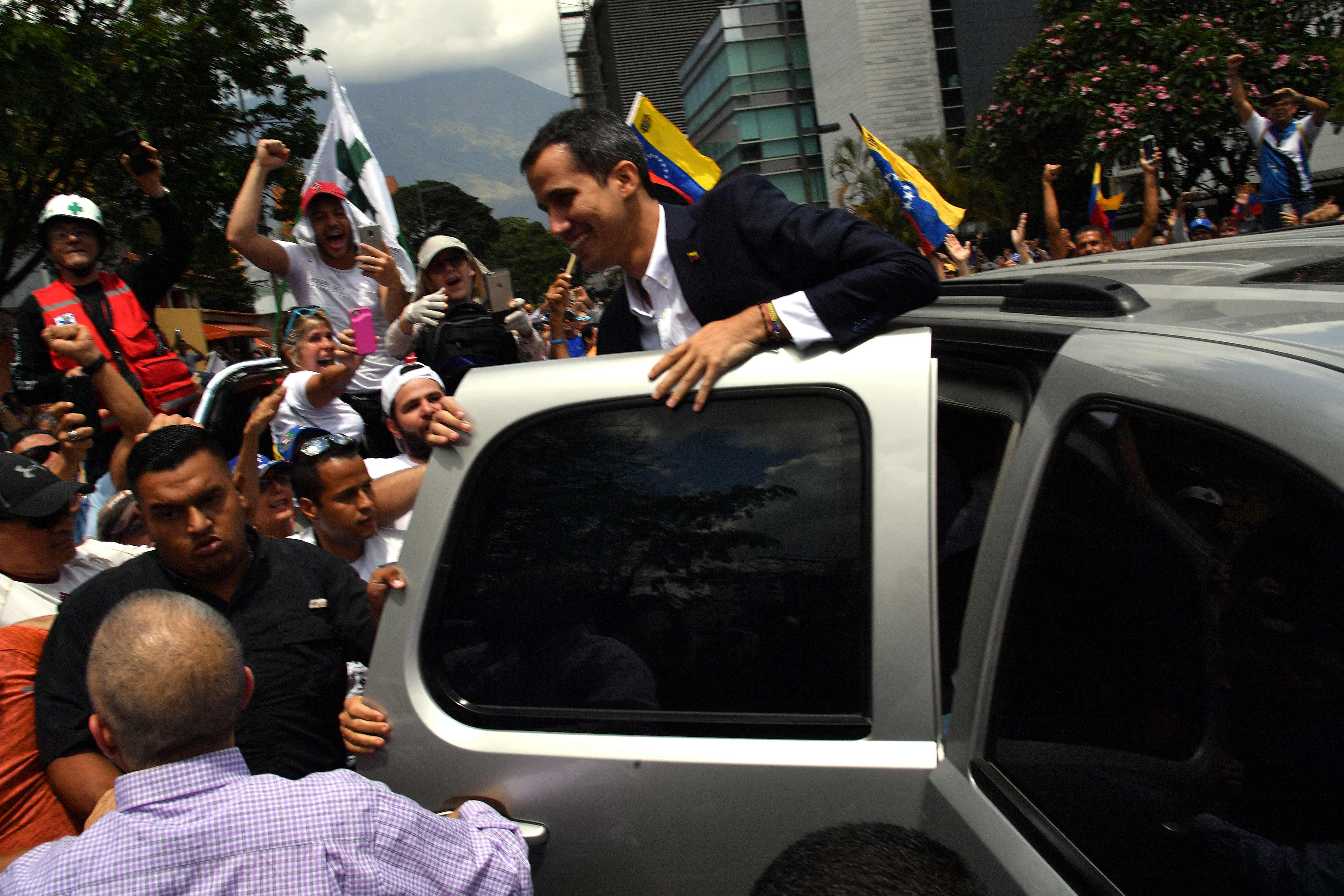 Juan Guaido saluda a simpatizantes al salir del aeropuerto internacional de Caracas. (Foto Prensa Libre: AFP)