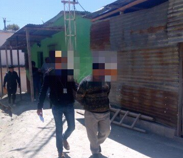 Agente de la PNC custodia a unos de los supuestos estafadores capturados en Chiantla. (Foto Prensa Libre: PNC).