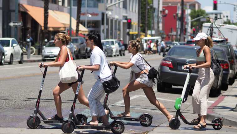 Personas se transportan en motos eléctricas compartidas en Estados Unidos. (Foto Prensa Libre: AFP)