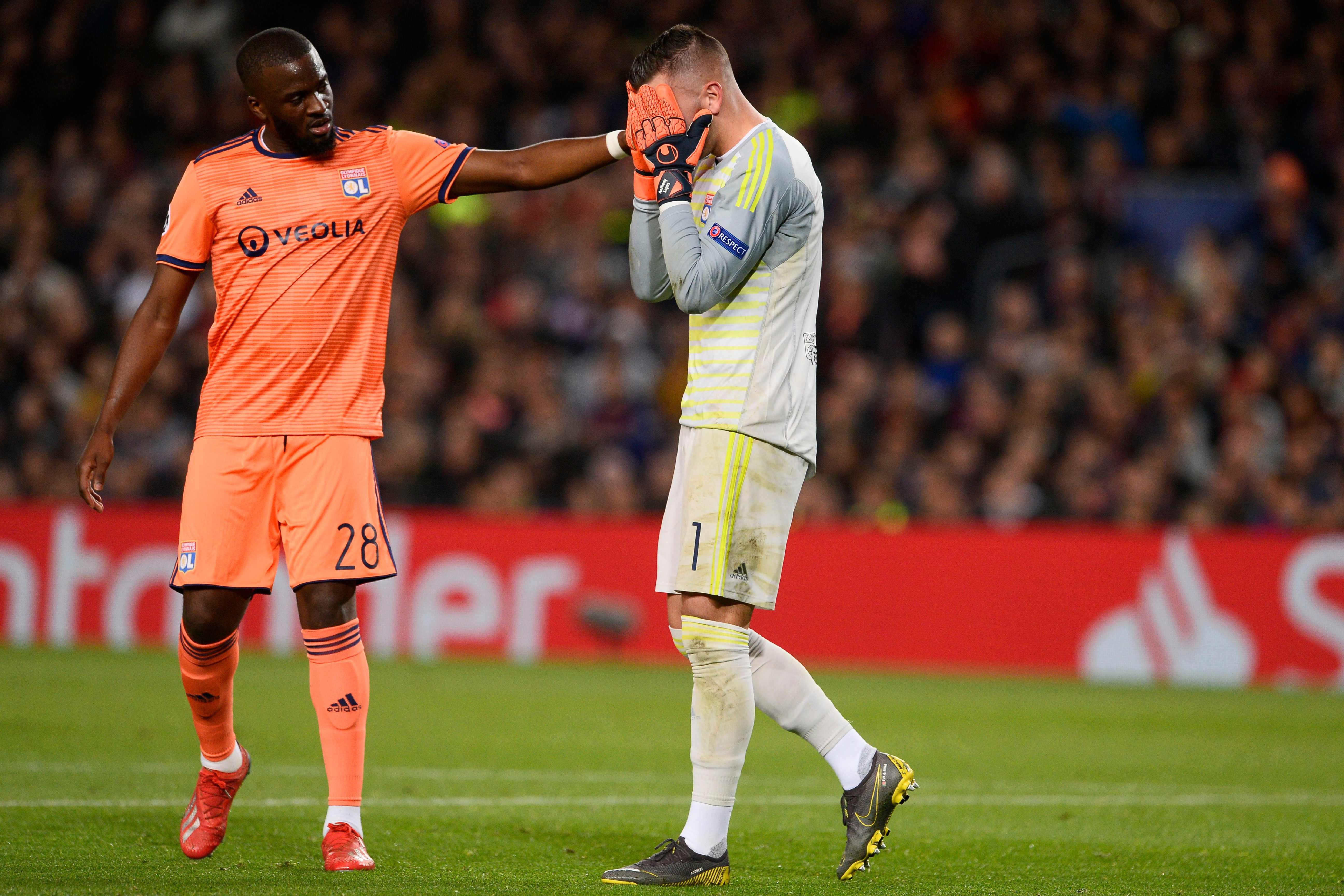 Lyon's French forward Tanguy NDombele Alvaro (L) conforts Lyon's Portuguese goalkeeper Anthony Lopes during the UEFA Champions League round of 16, second leg football match between FC Barcelona and Olympique Lyonnais at the Camp Nou stadium in Barcelona on March 13, 2019. (Photo by Josep LAGO / AFP)