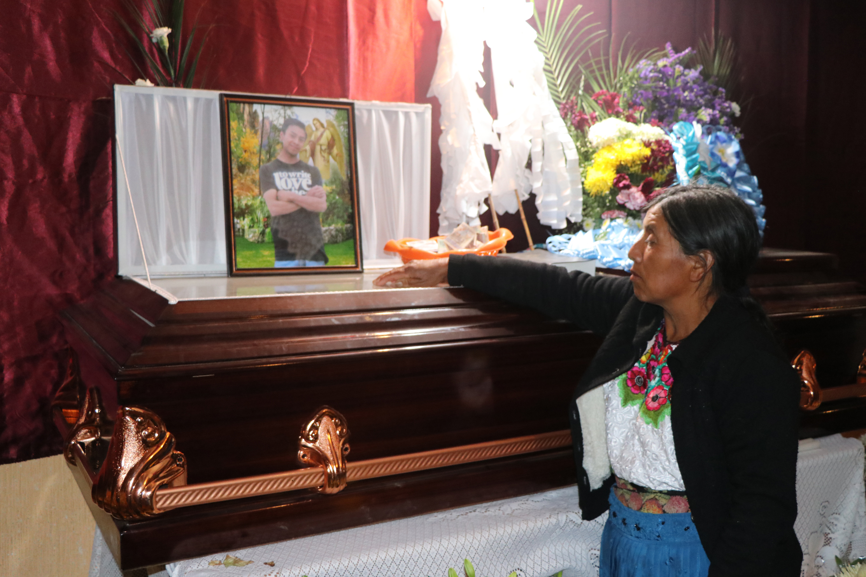 Olivia Estrada observa la foto de su hijo, Ronald Alberto López Estrada, quien murió en su viaje hacia Estados Unidos. (Foto Prensa Libre: Whitmer Barrera).