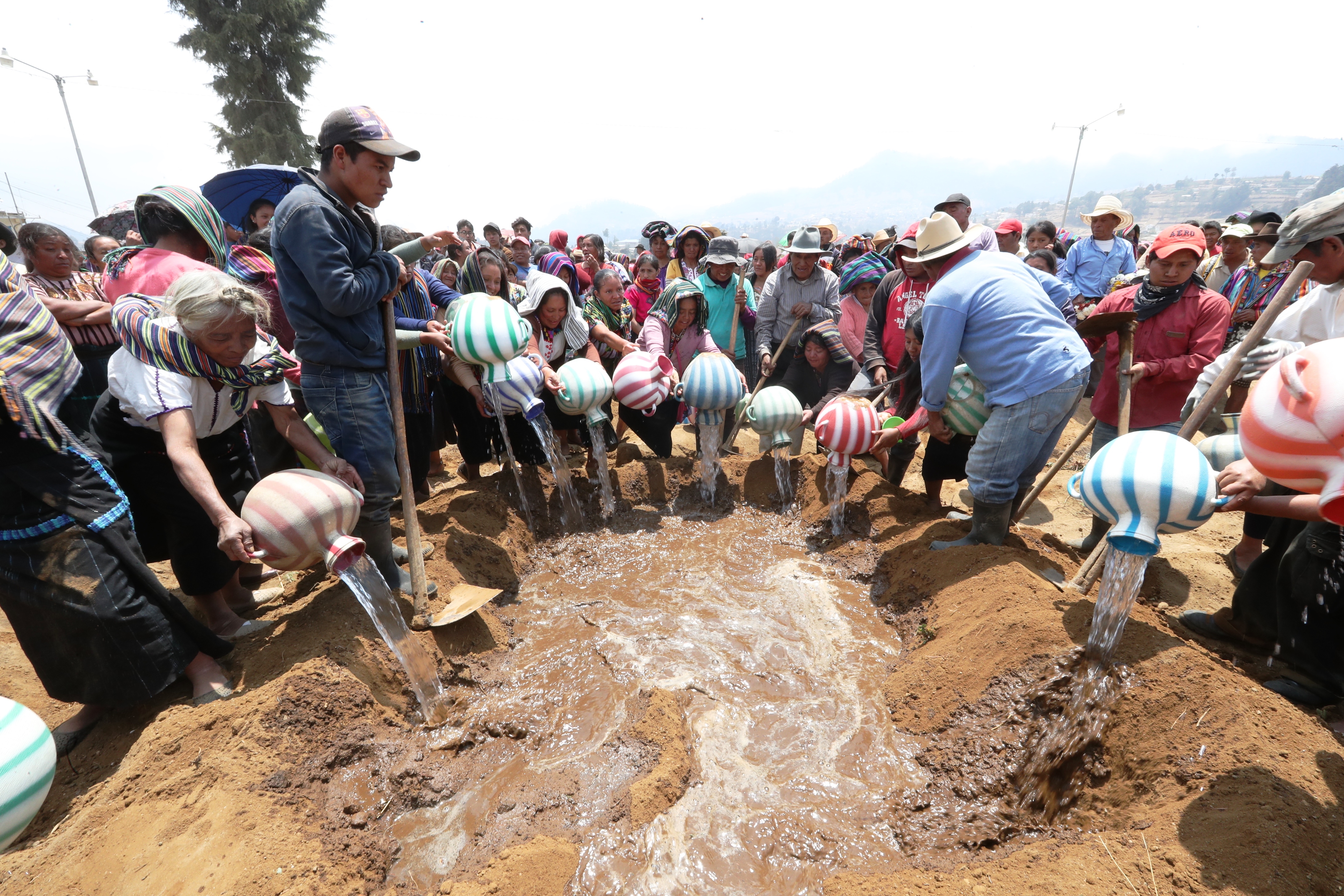 Mujeres de Nahualá echan agua a la tumba de la familia Perechú Cotiy. (Foto Prensa Libre: Mynor Toc)