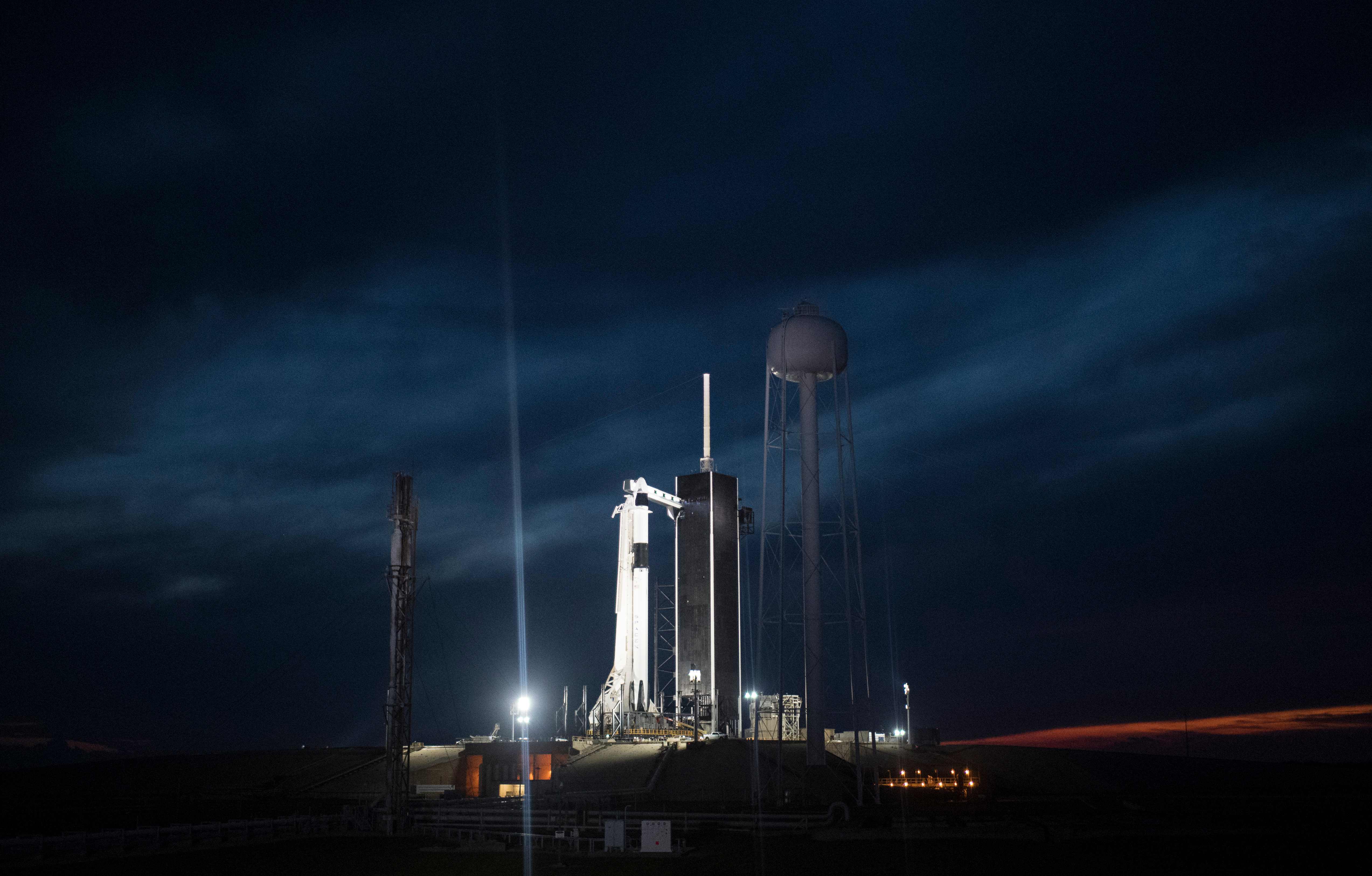 This handout photo released by NASA shows a SpaceX Falcon 9 rocket with the company's Crew Dragon spacecraft onboard illuminated on the launch pad by spotlights at Launch Complex 39A as preparations continue for the Demo-1 mission, March 1, 2019 at the Kennedy Space Center in Florida. - NASA and SpaceX were counting down the hours to the launch of a new astronaut capsule on a week-long return flight to the International Space Station, a key step towards resuming manned space flights from US soil after an eight-year break. (Photo by Joel KOWSKY / NASA / AFP) / RESTRICTED TO EDITORIAL USE - MANDATORY CREDIT "AFP PHOTO / NASA / JOEL KOWSKY " - NO MARKETING NO ADVERTISING CAMPAIGNS - DISTRIBUTED AS A SERVICE TO CLIENTS