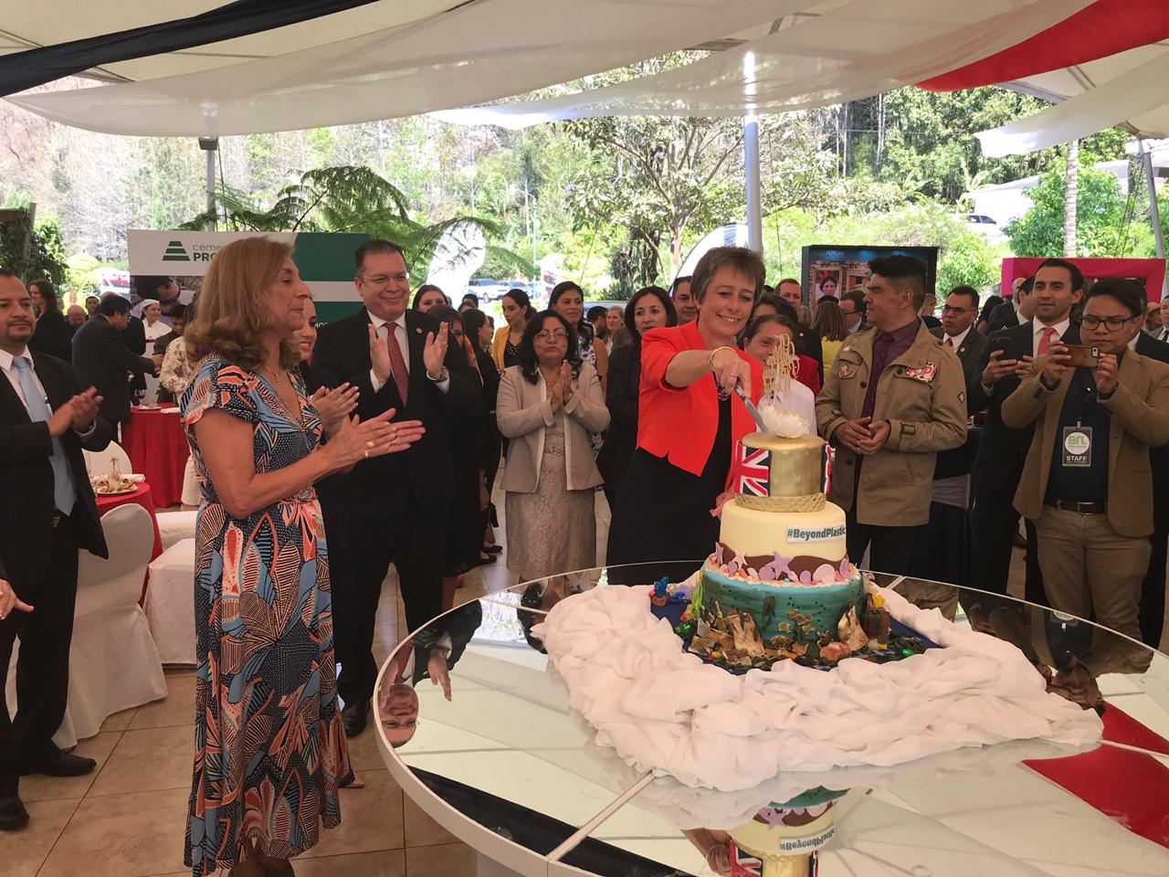 Carolyn Davidson, Embajadora Británica, al partir el pastel en honor de la Reina Elizabeth Segunda.