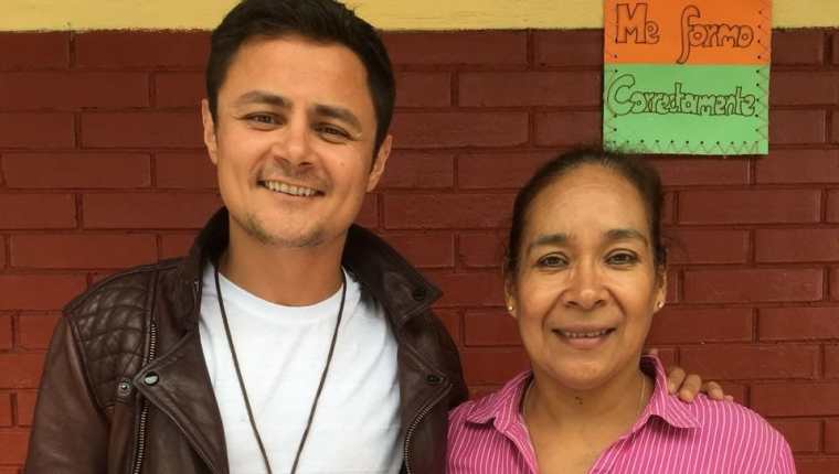 El actor guatemalteco Arturo Castro junto a Carmen Molina, directora del establecimiento educativo beneficiado. (Foto Prensa Libre: Cortesía)