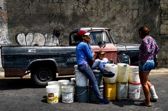 La gente espera con los recipientes para recoger el agua que fluye desde la montaña Wuaraira Repano, también llamada "El Ávila", en Caracas 