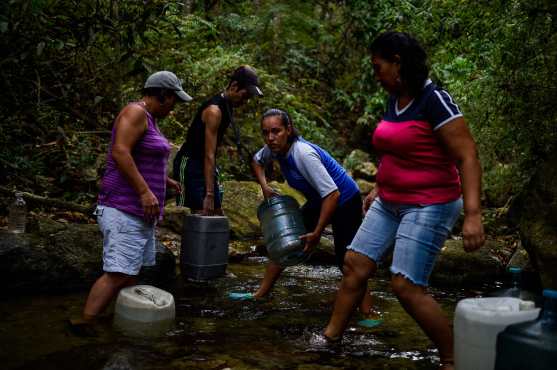 Venezolanos buscan agua en ríos y cualquier fuente en Caracas para poder llevar a sus casas. 