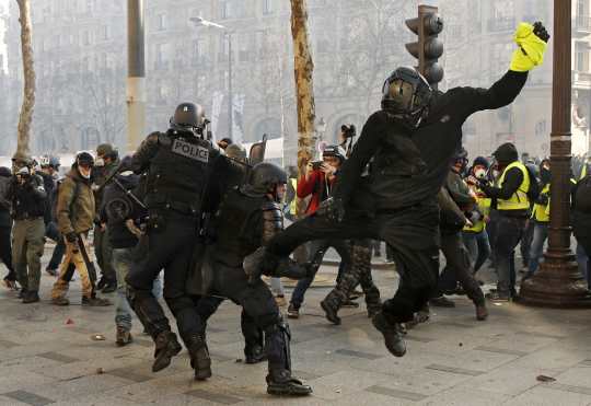 Un manifestante golpea a un policía durante las protestas de los Chalecos Amarillos en Francia. Foto Prensa Libre: EFE