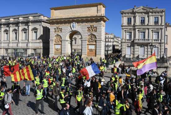 Los manifestantes de "chalecos amarillos" marchan frente a la Porte du Peyrou en Montpellier, en el sur de Francia. Foto Prensa Libre: AFP