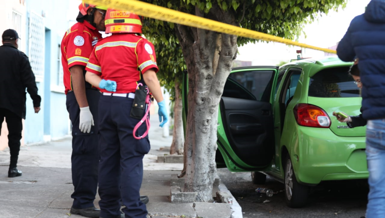 Socorristas observan las pastillas que se localizaron en el exterior del vehículo donde fue hallada la víctima. (Foto Prensa Libre: Óscar Rivas)