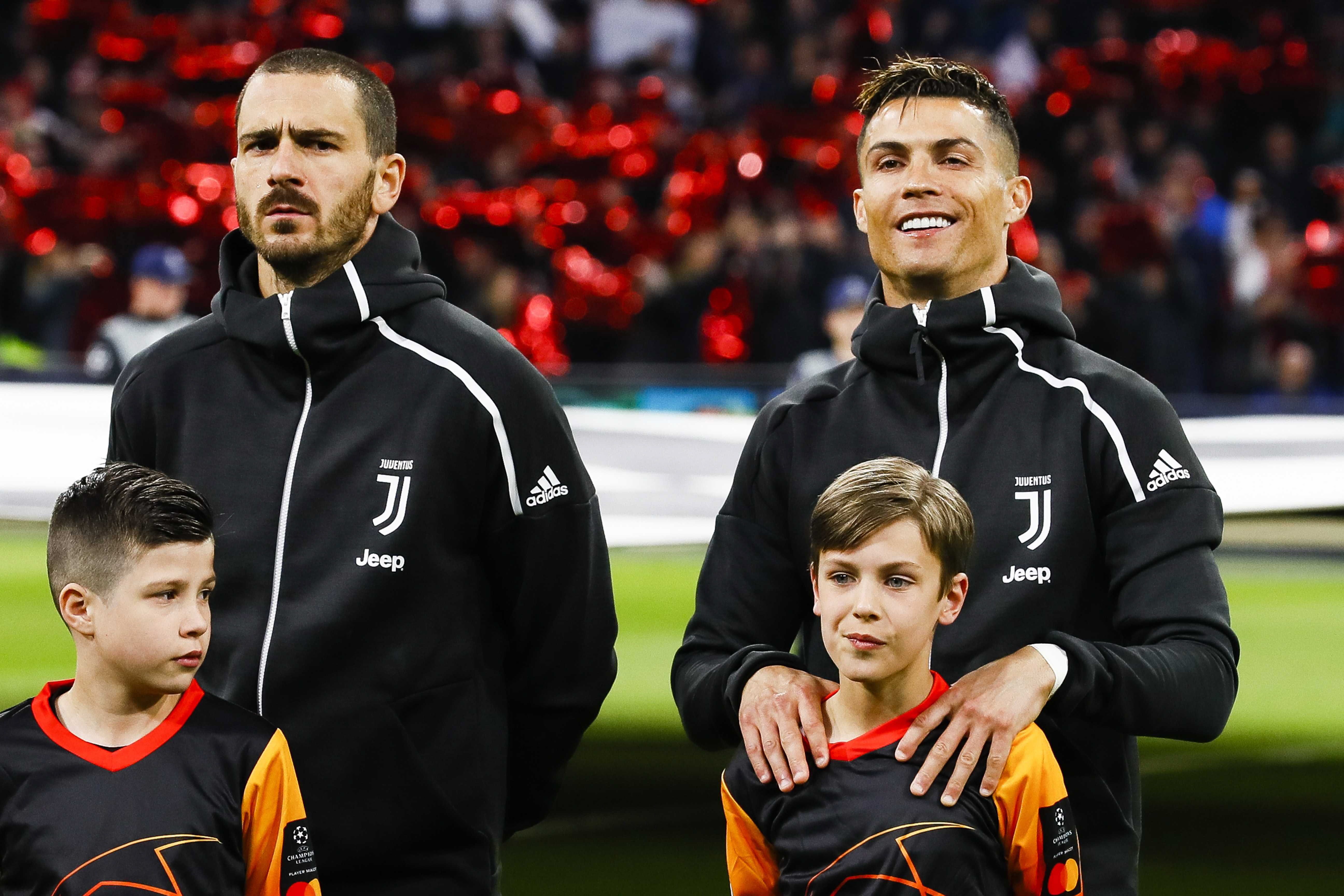 Cristiano Ronaldo (d) y Leonardo Bonucci (i) de la Juventus escuchan el himno este miércoles, durante el partido de ida de cuartos de final de la Liga de Campeones UEFA, entre el Ajax Amsterdam y la Juventus FC, en Ámsterdam (Holanda). (Foto Prensa Libre: EFE)