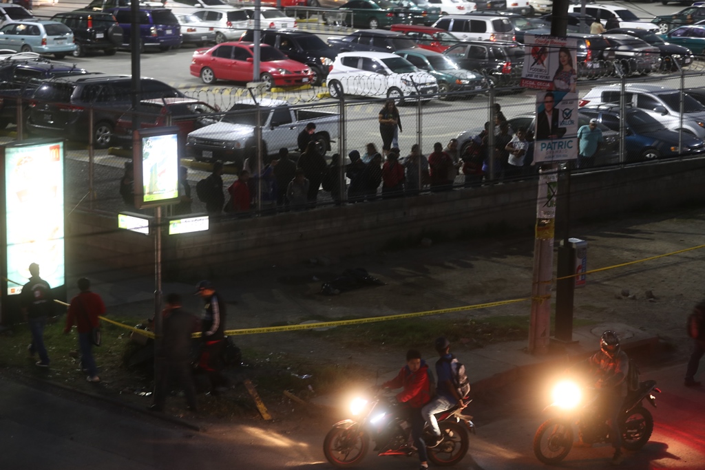 Curiosos observan el lugar donde murió baleada una mujer de 17 años , en la zona 2 de Xela. (Foto Prensa Libre: Mynor Toc)