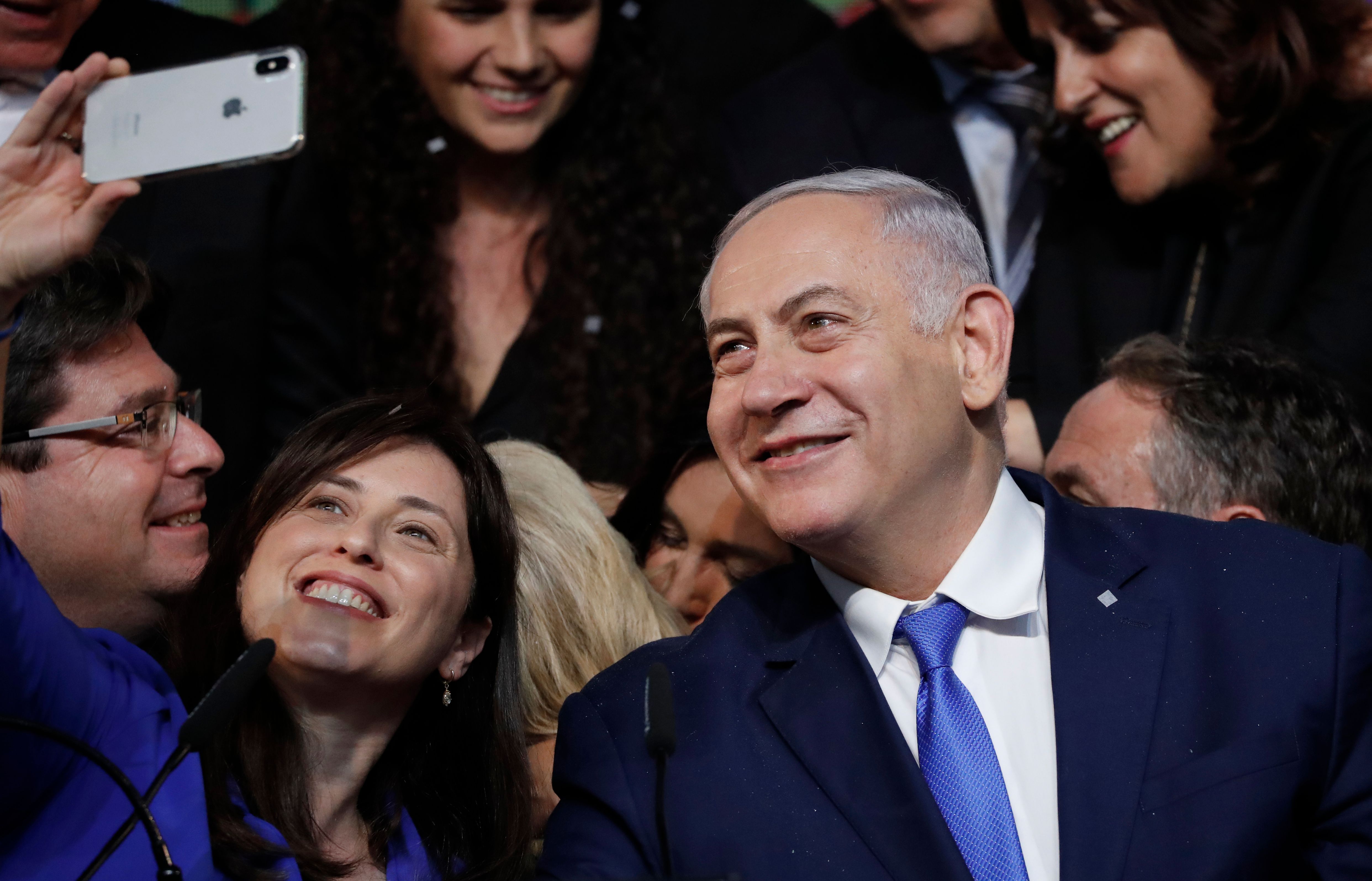 Israeli Prime Minister Benjamin Netanyahu (R) and Israeli Deputy Foreign Minister Tzipi Hotovely pose for a "selfie" photograph at his Likud Party headquarters in the Israeli coastal city of Tel Aviv on election night early on April 10, 2019. - The results from yesterday's vote came despite corruption allegations against the 69-year-old premier and put him on track to become Israel's longest-serving prime minister later this year. (Photo by THOMAS COEX / AFP)