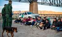 (FILES) In this file photo taken on March 20, 2019 a group of about 30 Brazilian migrants, who had just crossed the border, sit on the ground near US Border Patrol agents, on the property of Jeff Allen, who used to run a brick factory near Mt. Christo Rey on the US-Mexico border in Sunland Park, New Mexico. - The White House confirmed on April 14, 2019 it is looking at ways to transfer undocumented migrants to US sanctuary cities as Democrats accused President Donald Trump of creating "manufactured chaos" at the US-Mexico border."This is an option on the table," White House press secretary Sarah Sanders said in an interview on ABC's "This Week."Trump "heard the idea, he likes it, so - well, we're looking to see if there are options that make it possible and doing a full and thorough and extensive review," she said. (Photo by Paul Ratje / AFP)