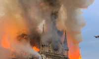 Flames and smoke are seen billowing from the roof at Notre-Dame Cathedral in Paris on April 15, 2019. - A fire broke out at the landmark Notre-Dame Cathedral in central Paris, potentially involving renovation works being carried out at the site, the fire service said.Images posted on social media showed flames and huge clouds of smoke billowing above the roof of the gothic cathedral, the most visited historic monument in Europe. (Photo by Patrick ANIDJAR / AFP)