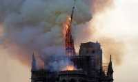 The steeple of the landmark Notre-Dame Cathedral collapses as the cathedral is engulfed in flames in central Paris on April 15, 2019. - A huge fire swept through the roof of the famed Notre-Dame Cathedral in central Paris on April 15, 2019, sending flames and huge clouds of grey smoke billowing into the sky. The flames and smoke plumed from the spire and roof of the gothic cathedral, visited by millions of people a year. A spokesman for the cathedral told AFP that the wooden structure supporting the roof was being gutted by the blaze. (Photo by Geoffroy VAN DER HASSELT / AFP)